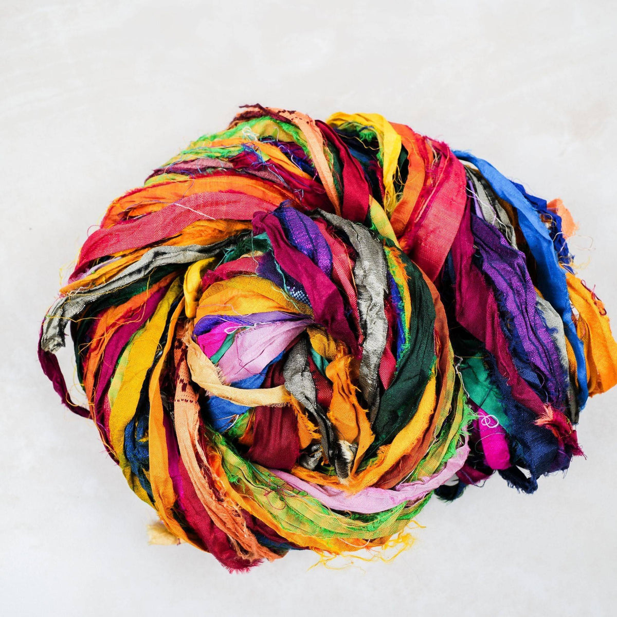 At the Bahamas recycled sari silk ribbon showing varied jewel-tone strips and naturally frayed edges