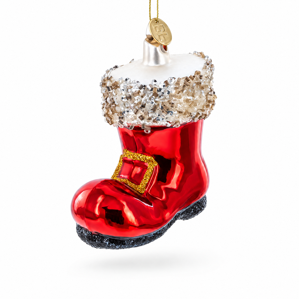 A red Christmas ornament shaped like a Santa-style boot, with a white faux-fur cuff covered in silver glitter, a gold buckle detail, and a black glitter sole, hanging against a white background.