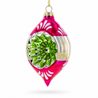 A glass Christmas ornament with a bright pink and silver body, featuring a green textured pine tree design in the center and white decorative patterns near the top and bottom, hanging against a white background.