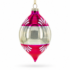 A clear glass Christmas ornament with a metallic magenta top and bottom section, decorated with white leaf patterns, hanging from a gold string against a white background.