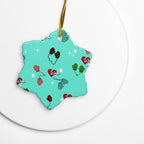 Vintage-inspired ceramic Christmas ornament with colorful children’s mittens on an aqua background