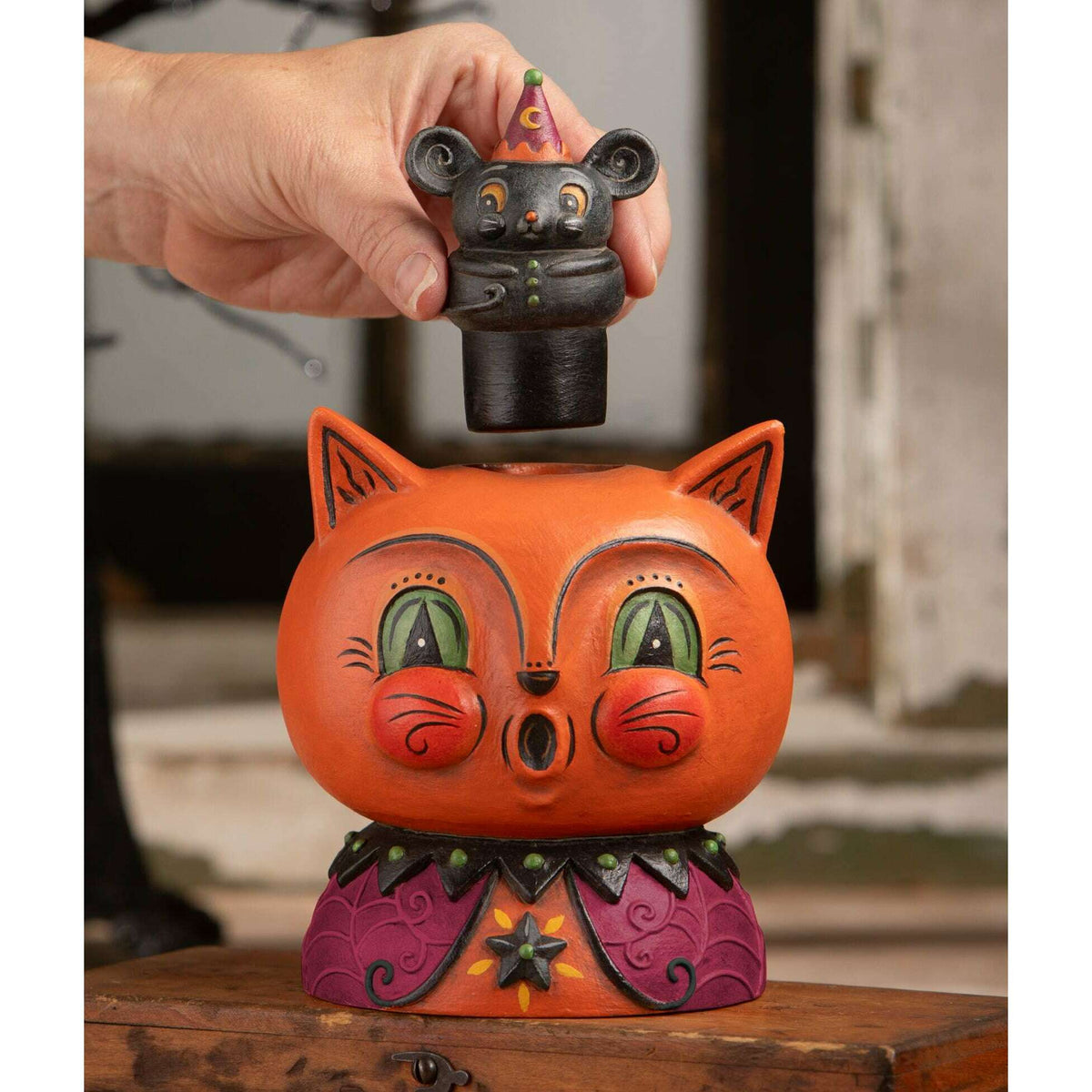 Hand holding Merlin Mouse above Copper Cat to show the removable mouse and hidden compartment inside the Halloween decoration.