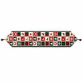A festive Christmas-themed table runner with a repeating pattern of red, green, and cream holiday motifs, finished with red tassels on both ends.
