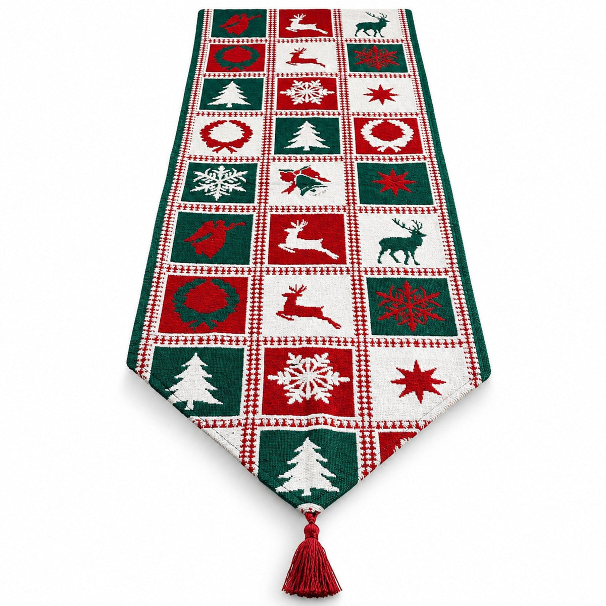 A festive Christmas table runner with a red, green, and white patchwork design featuring holiday motifs like snowflakes, Christmas trees, reindeer, and stars, finished with a red tassel at the bottom.