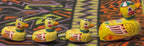 Colorful vintage tin duck family toy displayed in a row