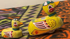 Close-up of the brightly colored lithographed details on the tin duck toy