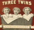 Front of antique Three Twins cigar box label featuring three babies in a wicker basket against a red background