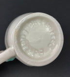 bottom White vintage Bailey’s ceramic creamer shaped like a smiling face with one eye winking, a blue bow, and a small handle.