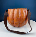 Vintage orange papier-mâché jack-o’-lantern basket with a hand-painted smiling face, blue eyes, and a crackled finish.