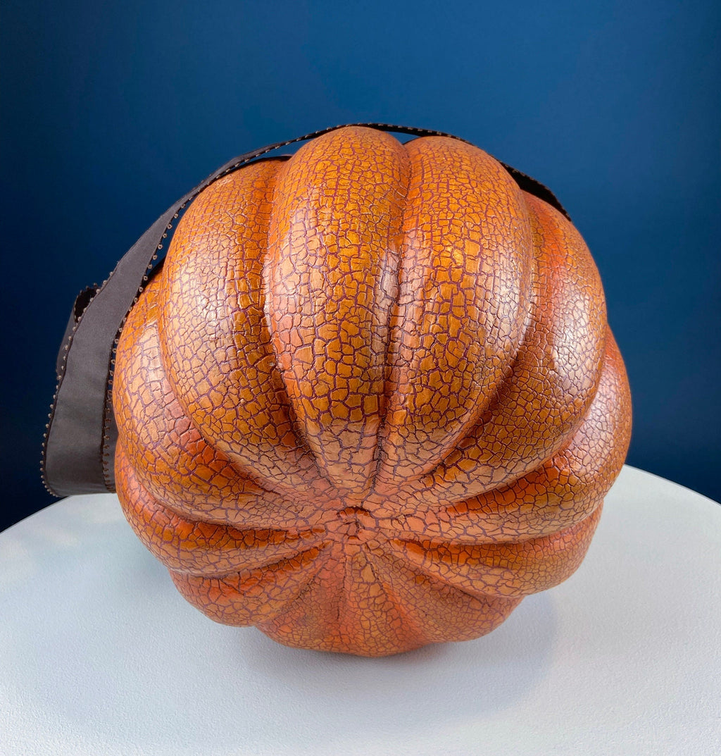 Vintage orange papier-mâché jack-o’-lantern basket with a hand-painted smiling face, blue eyes, and a crackled finish.