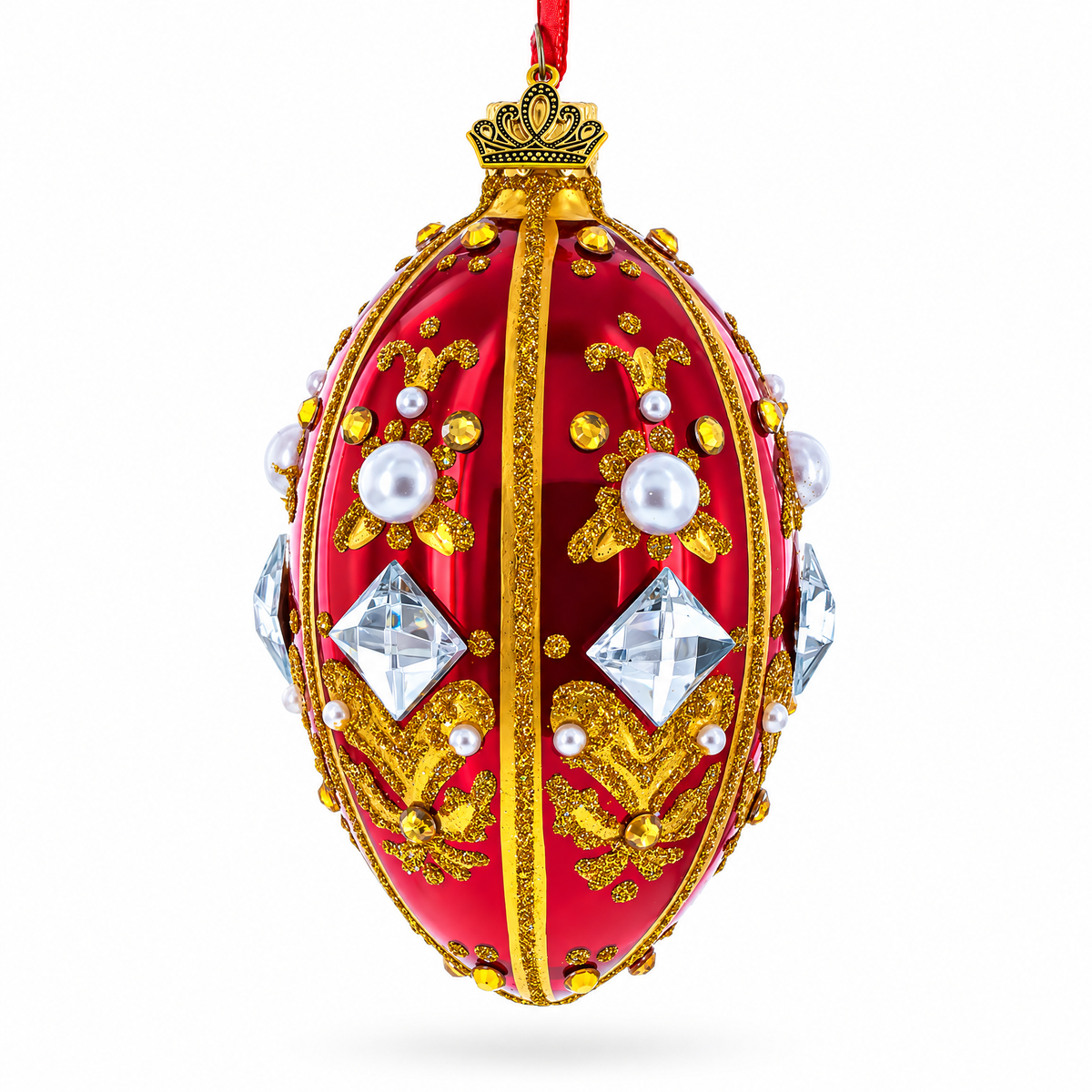 Side view of red glass egg ornament decorated with gold detailing, pearls and colorful jewels