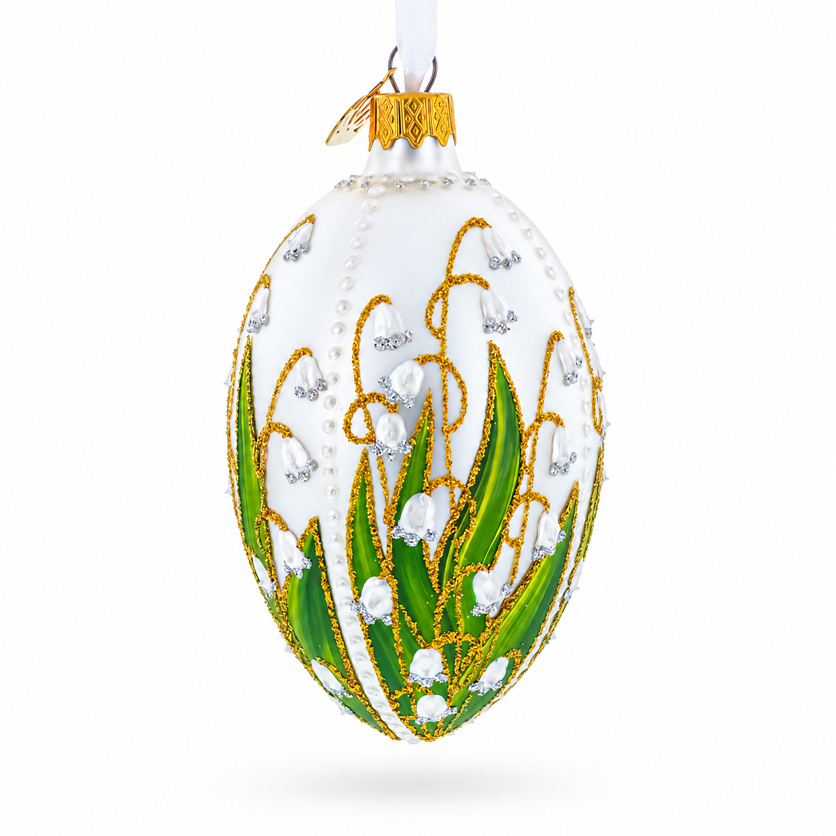 Side view of lily of the valley glass egg ornament with hand-painted green leaves, white flowers, pearl accents and gold detailing