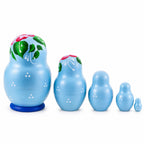 Light blue wooden nesting dolls shown from the back with hand-painted green leaves and red floral accents