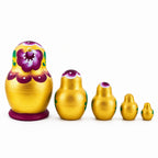 Back view of gold and violet wooden nesting dolls, set of five