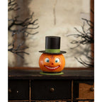 Smiling Pumpkin Container displayed on a dark wooden cabinet with vintage-inspired Halloween decorations.