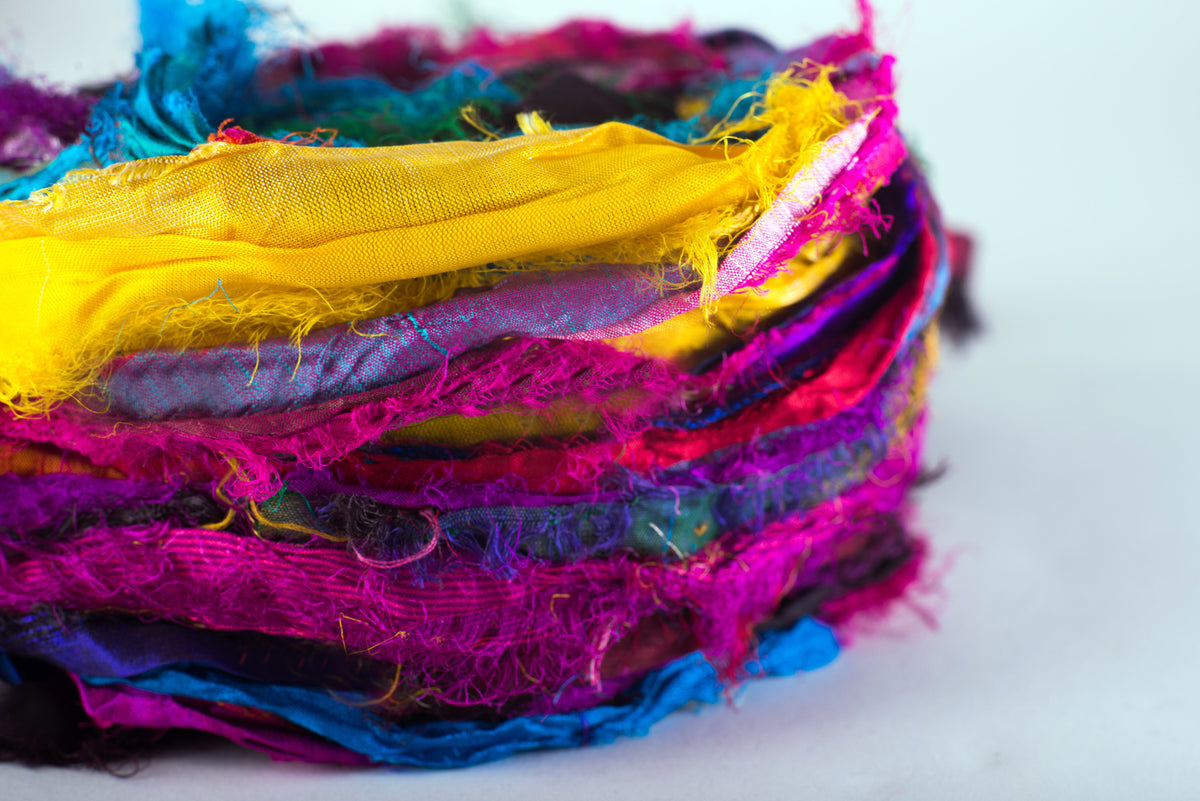 Close-up of Tibet Jewels recycled sari silk ribbon showing colorful frayed edges and varied textures