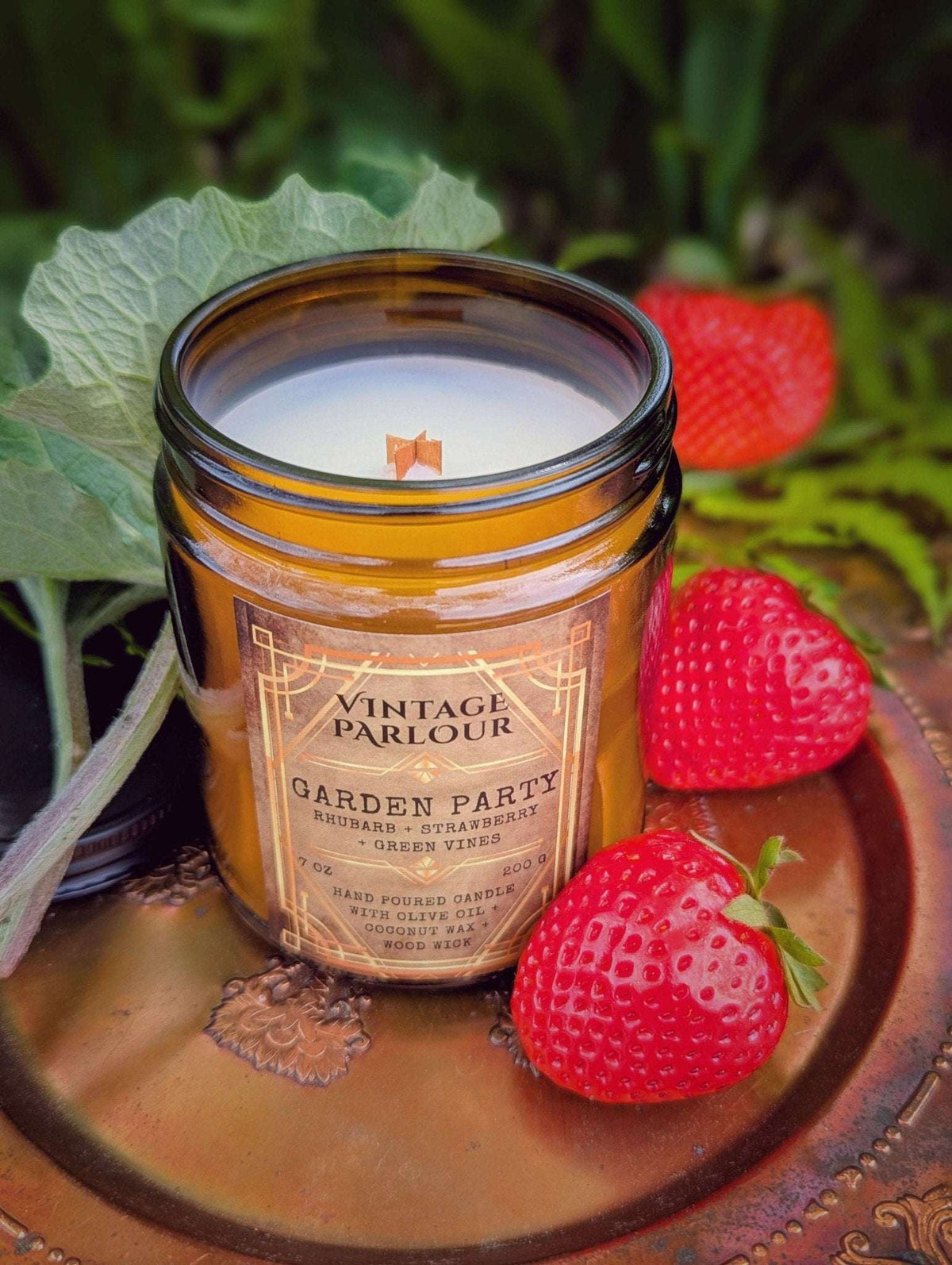 Vintage Parlour Garden Party wooden wick candle in an amber glass jar styled with fresh strawberries and greenery
