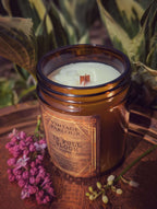 Vintage Parlour In Full Bloom wooden wick candle in an amber glass jar styled with lilac flowers and greenery