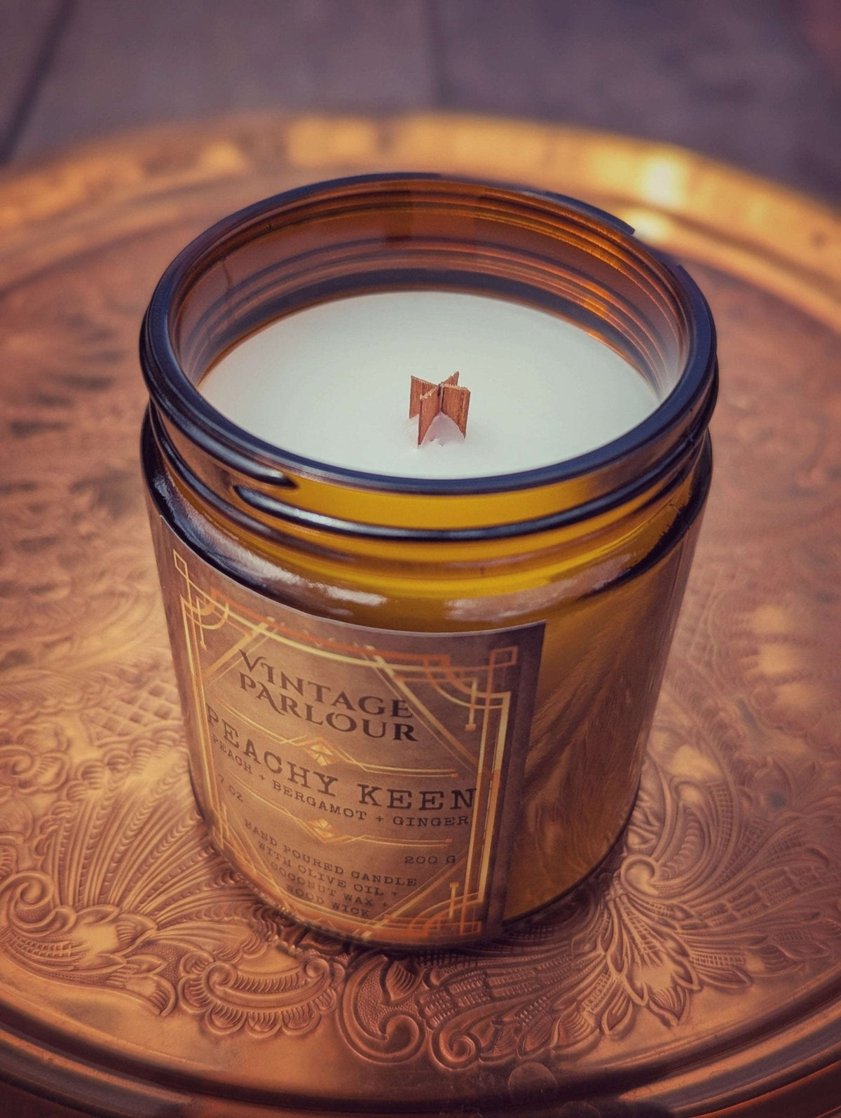 Vintage Parlour Peachy Keen wooden wick candle in an amber glass jar on an ornate vintage-style surface